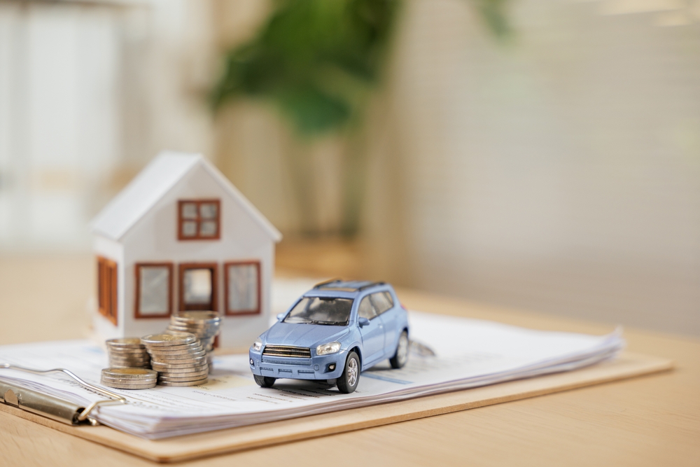 Miniature model house and toy car on a table